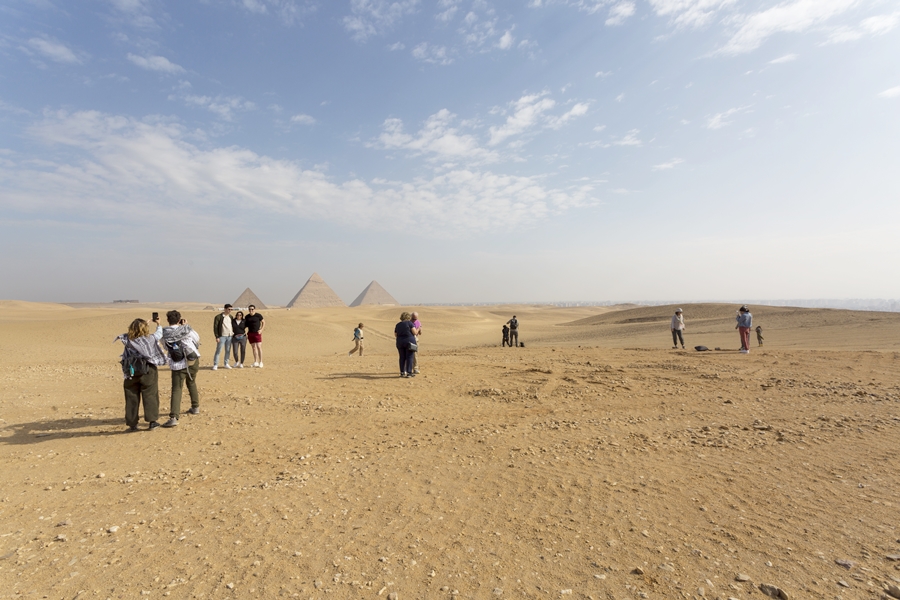 Piramidy w Gizie - turysci fotografują się na tle piramid